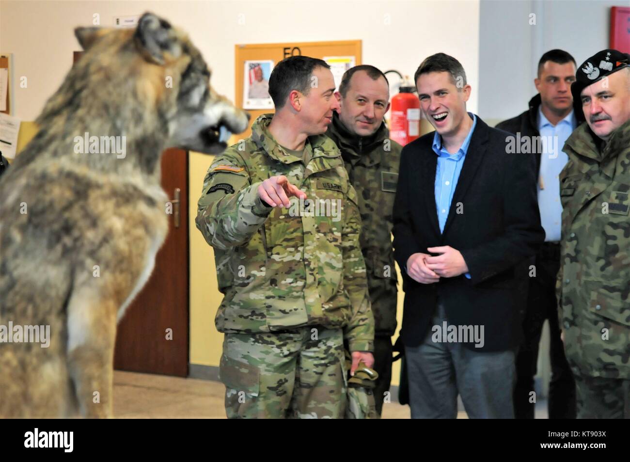 Us-Armee Oberstleutnant Scott Cheney, Battle Group Polen Commander, Links, erklärt die Geschichte des Regiments Wolf Pack Maskottchen zu U.K. Verteidigungsminister Gavin Williamson, Mitte, während eines Urlaubs besuchen Sie den NATO-Soldaten der Schlacht Gruppe Polen Dezember 22, im Bemowo Piskie, Polen 2017. Stockfoto