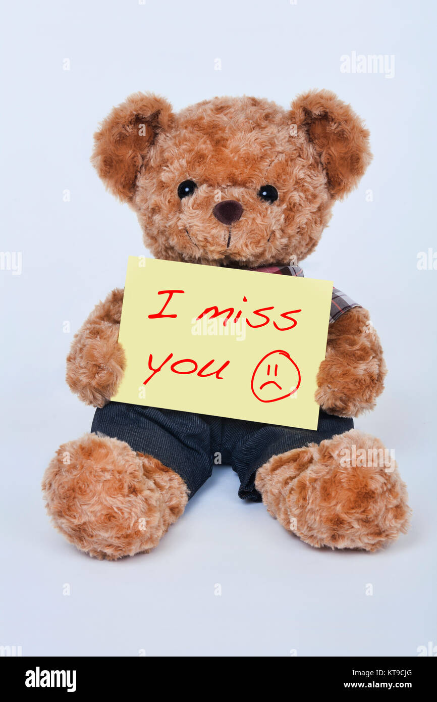 Eine niedliche Teddybär Holding ein gelbes Schild, das sagt, ich vermisse sie auf weißem Hintergrund Stockfoto