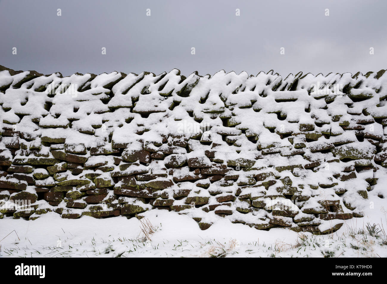 Traditionelle Trockenmauern Mauer mit Schnee bedeckt. Peak District, Derbyshire, England. Stockfoto