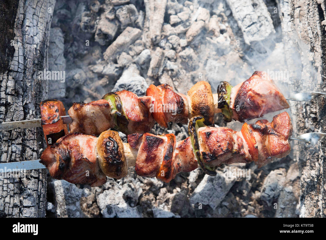 Saftige Scheiben von Fleisch mit Soße vorbereiten auf Feuer Stockfoto