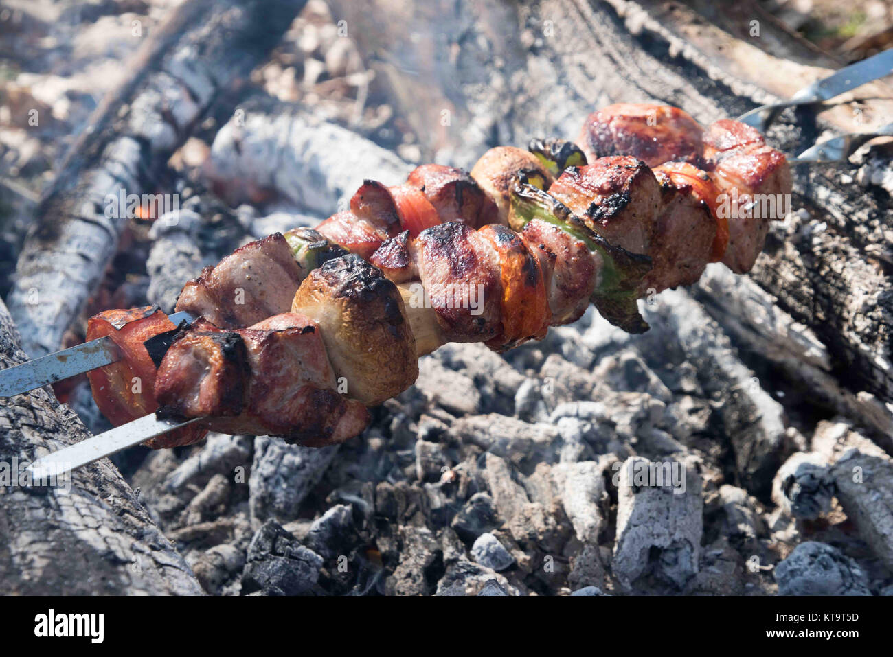 Saftige Scheiben von Fleisch mit Soße vorbereiten auf Feuer Stockfoto