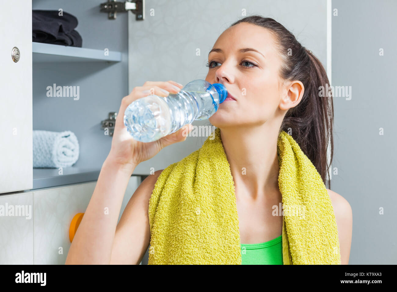 Mädchen Trinkwasser in der Umkleide nach dem fitness training Stockfoto