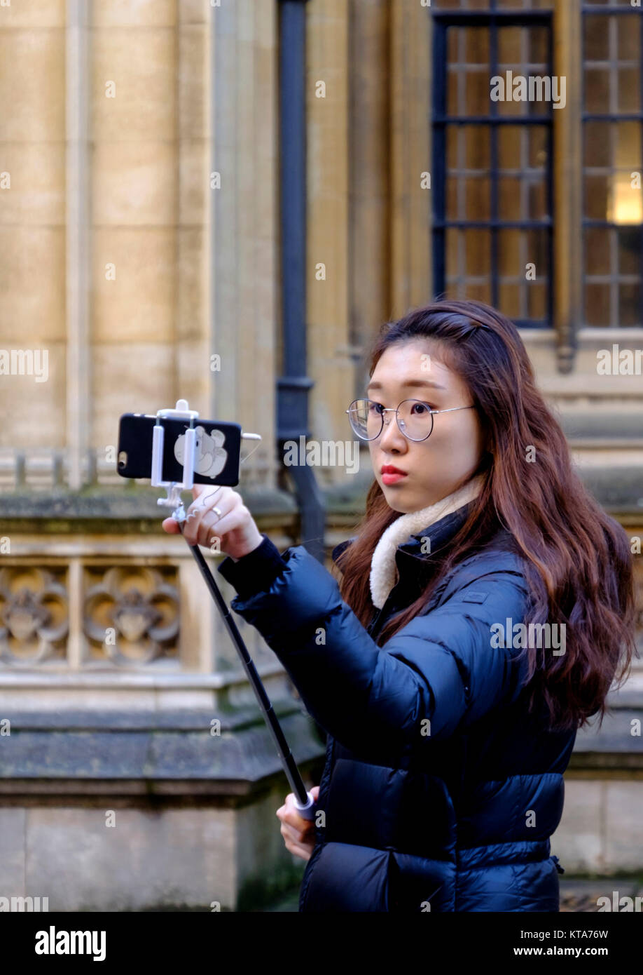 Rund um die University City of Oxford EIN Tourist, der ein Selfie Stockfoto