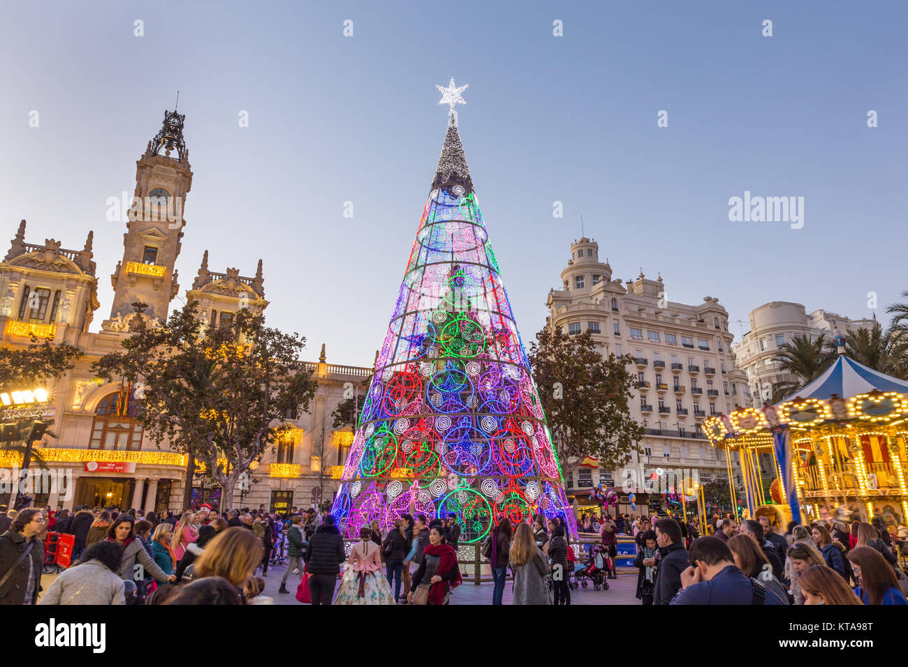 Weihnachtsmarkt mit bunten Weihnachtsbaum und Karussell auf Modernisme Plaza der Stadt Halle von Valencia, Spanien. Stockfoto