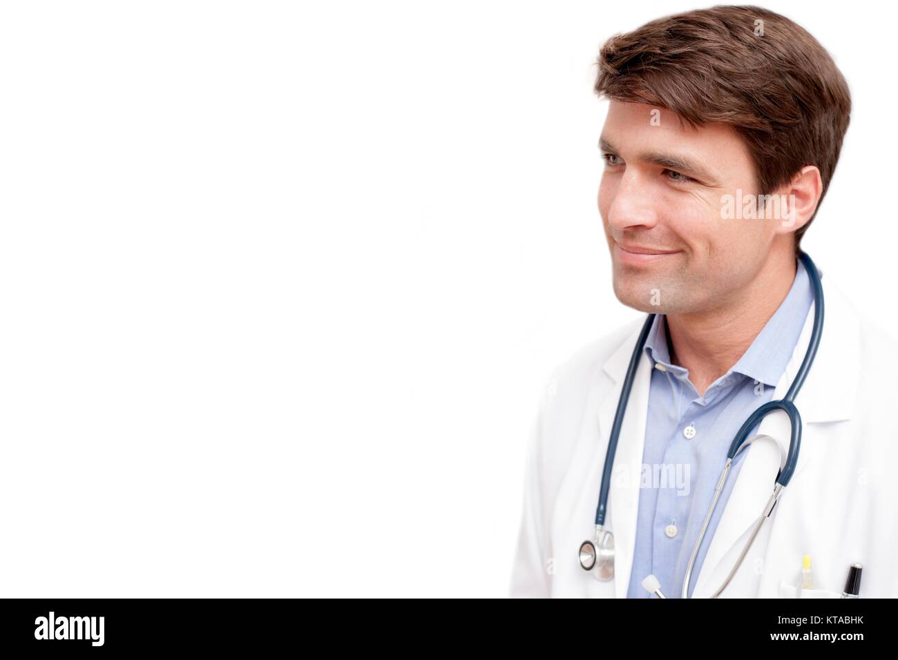 Männlicher Arzt gegen den weißen Hintergrund weg schauen, lächeln, Porträt. Stockfoto