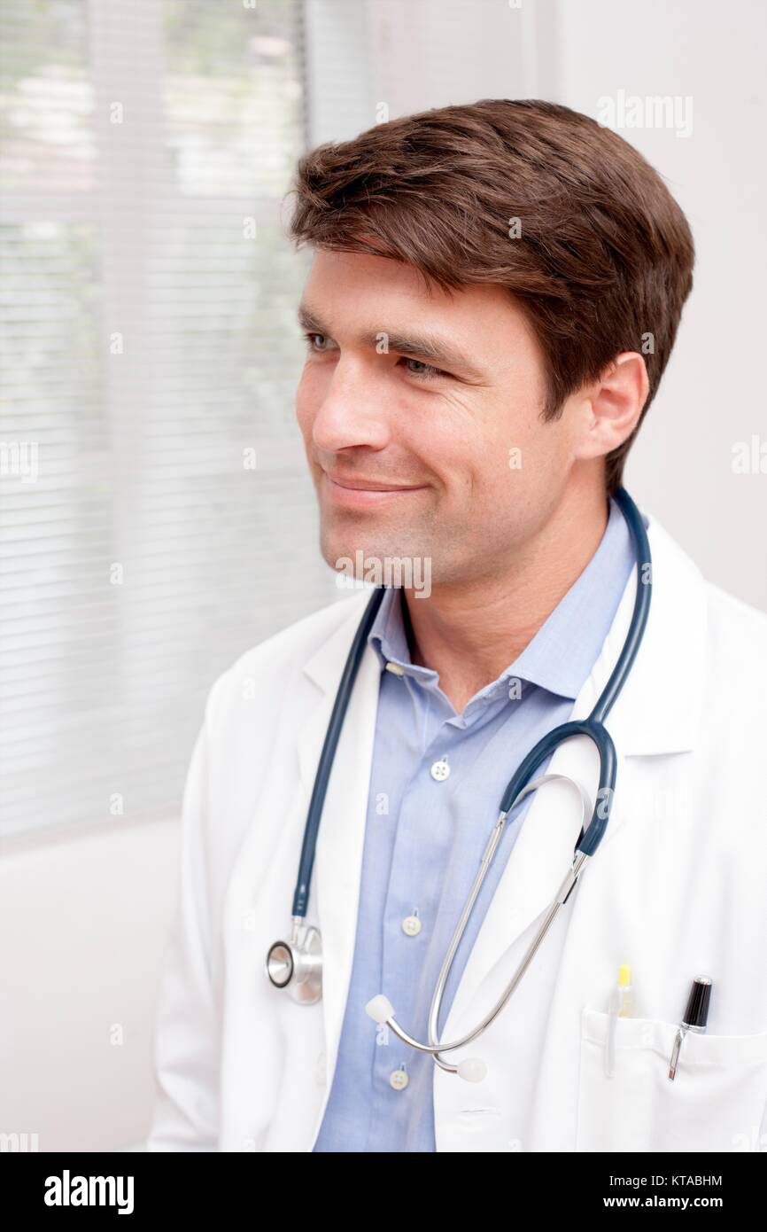 Männlicher Arzt in Uniform weg schauen, lächeln, Porträt. Stockfoto