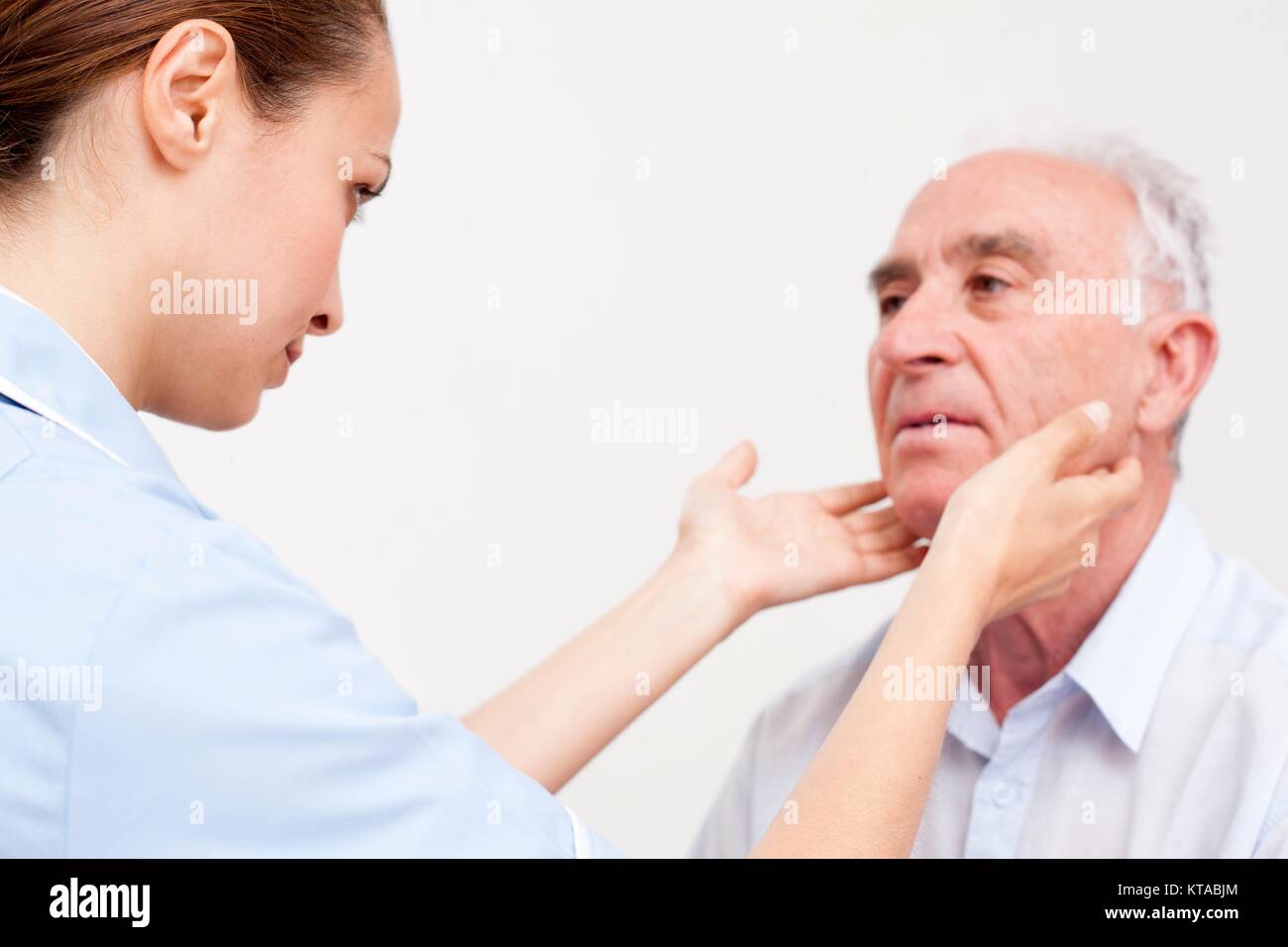 Krankenschwester Kontrolle Drüsen des älteren Mannes. Stockfoto