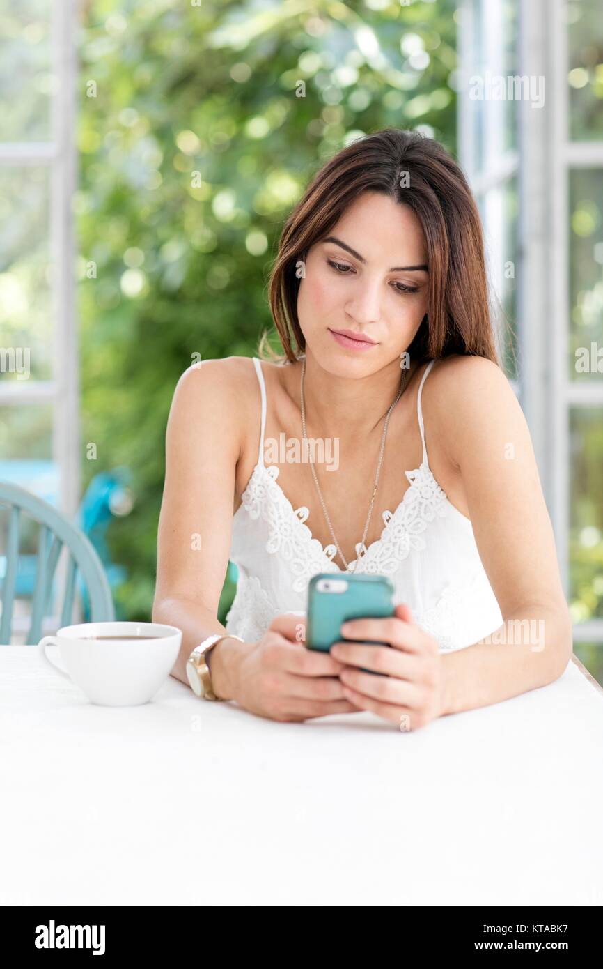 Junge Frau von SMS-Nachrichten auf dem Smartphone. Stockfoto
