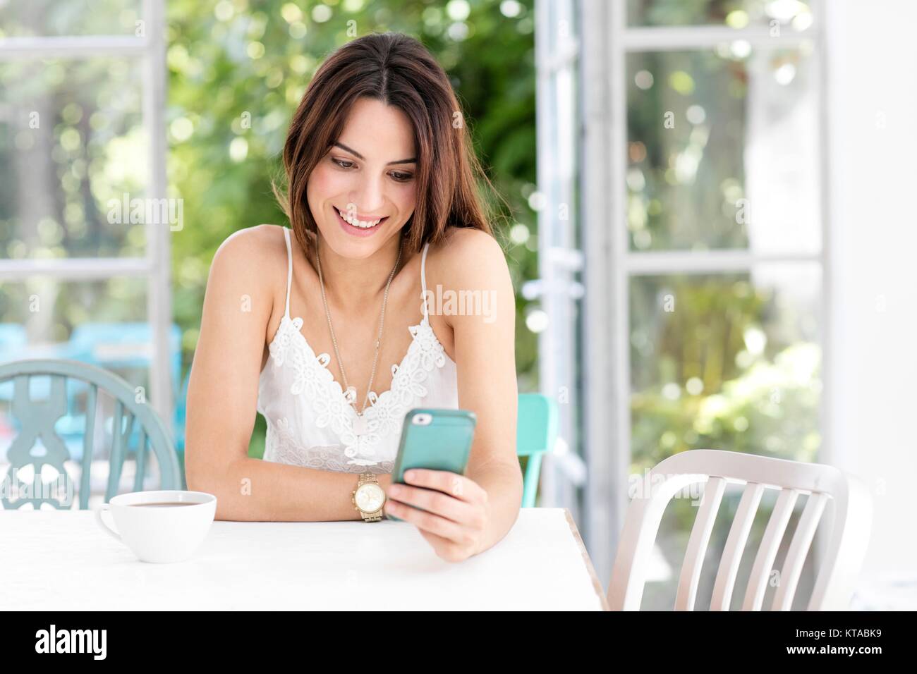Junge Frau von SMS-Nachrichten auf dem Smartphone. Stockfoto
