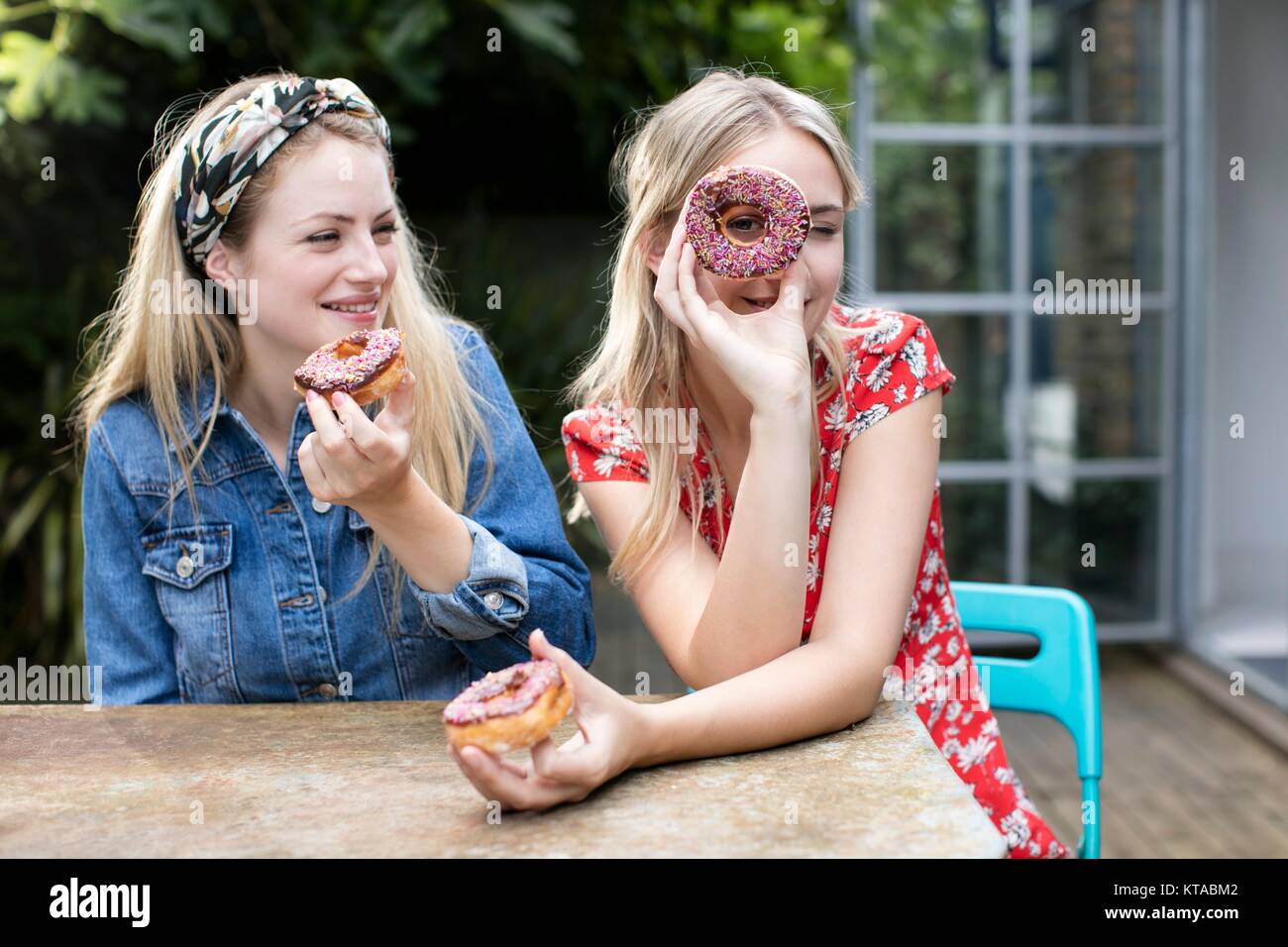 Zwei junge Frauen mit Donuts. Stockfoto