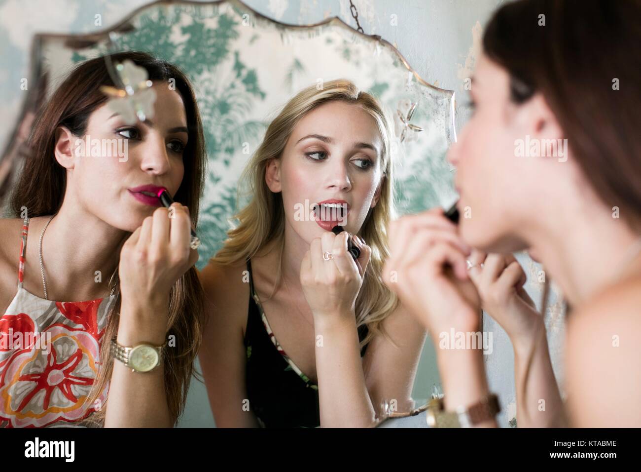 Junge Frauen, die Lippenstift im Spiegel. Stockfoto