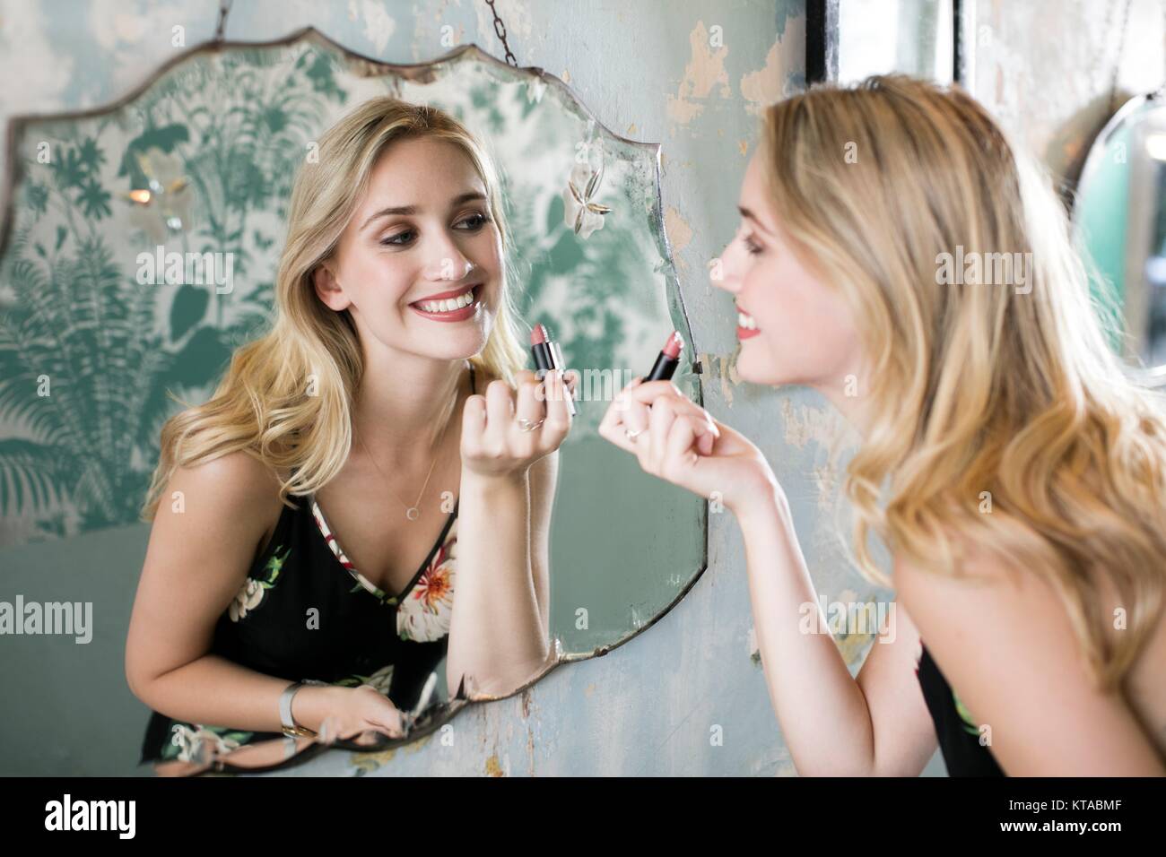Junge Frau Anwendung Lippenstift im Spiegel. Stockfoto