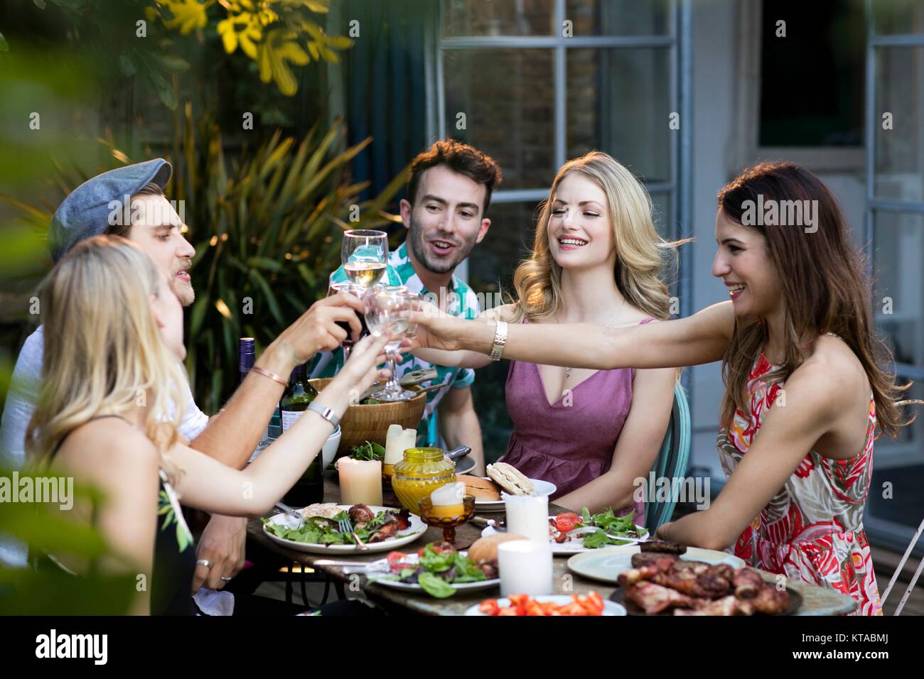 Gruppe von Freunden Toasten mit Wein über das Mittagessen im Freien. Stockfoto