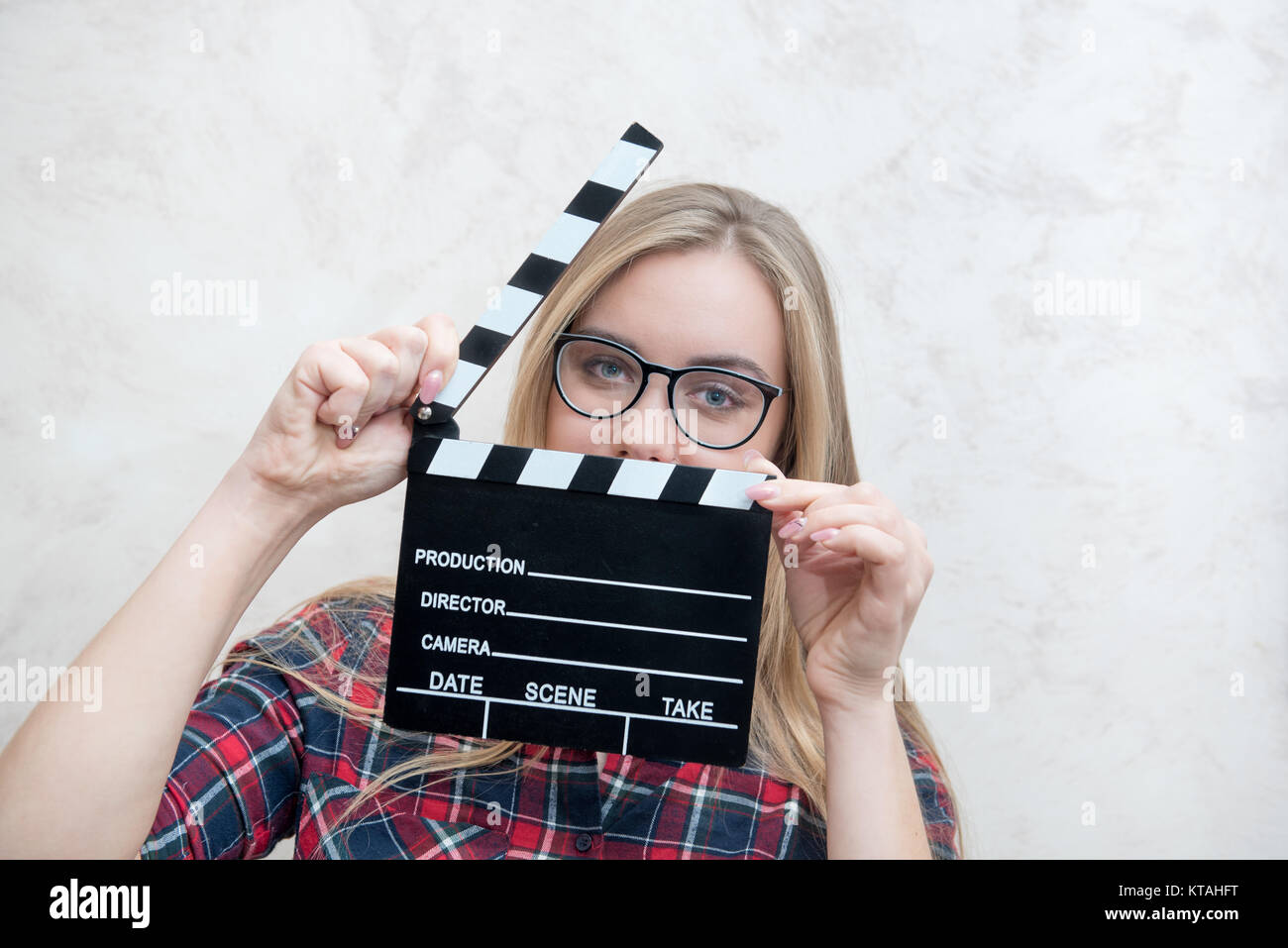 Junge blonde Frau, die Schauspielerin mit Movie clapper board Augen posiert ganz nah an der Kamera auf der Suche Stockfoto