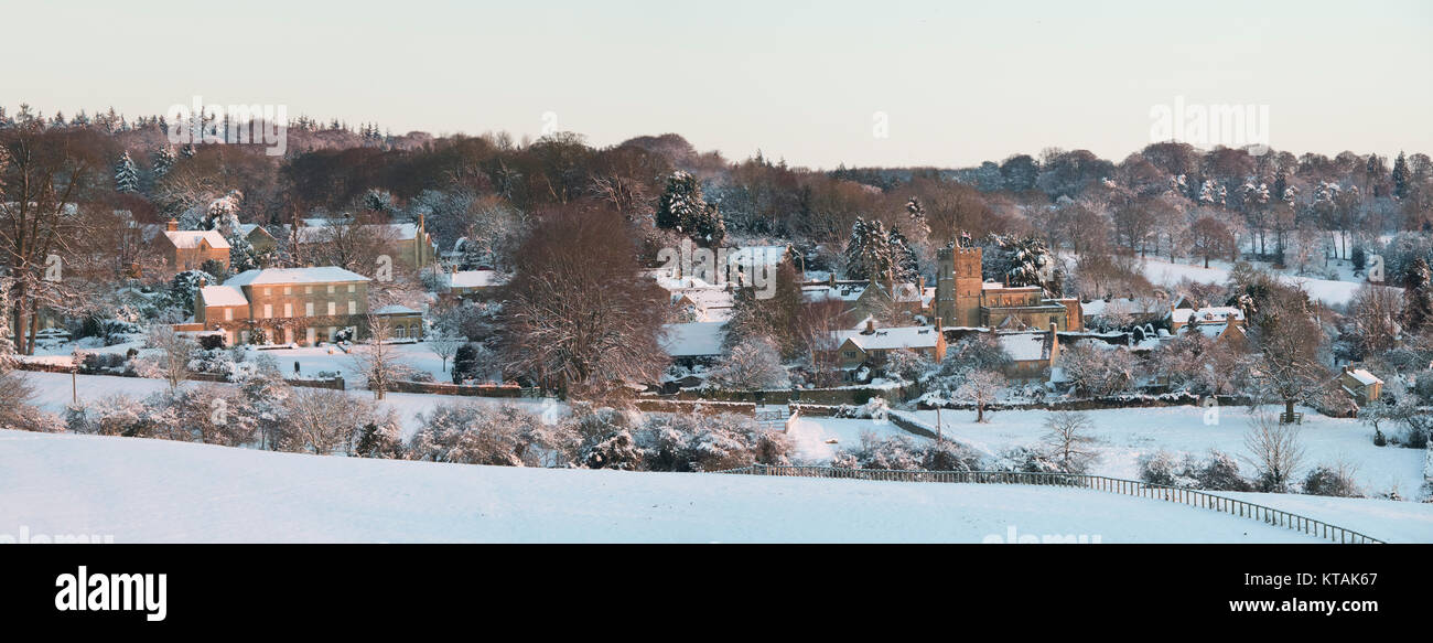 Bourton auf dem Hügel im Schnee bei Sonnenaufgang im Dezember. Bourton auf dem Hügel, Cotswolds, Gloucestershire, England. Panoramablick Stockfoto