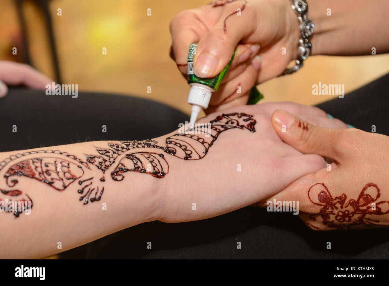 Person lässt sich Arm mit Henna-Muster gestalten Stockfoto