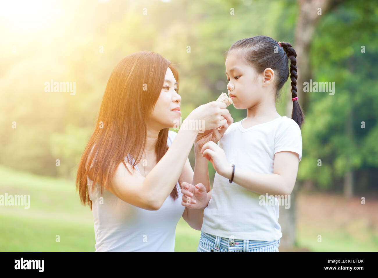 Mutter und Töchter essen im Freien Park. Stockfoto