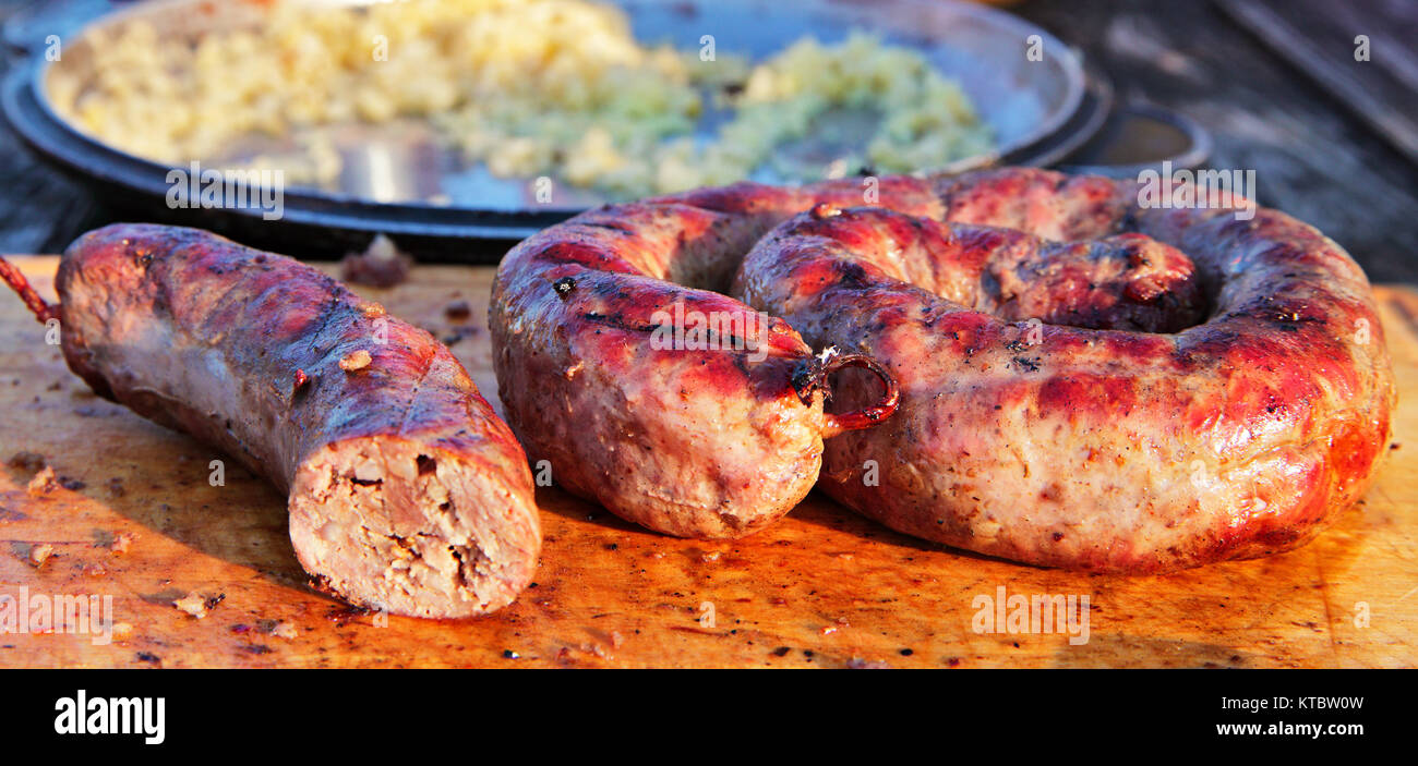 Leckere Würstchen auf Holzplatte auf Barbecue Grill zubereitet Stockfoto