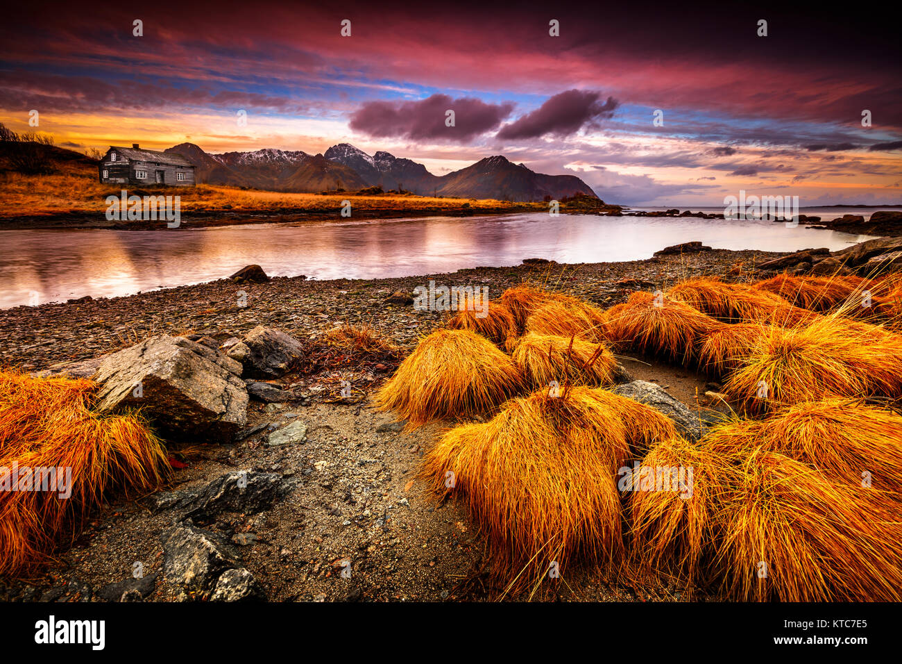 Schöne Landschaft von Vestvagoy am Abend, dramatische rosa Himmel über kleine Haus am Ufer des Flusses, Teil der Lofoten Island, Polarkreis, Nord Stockfoto