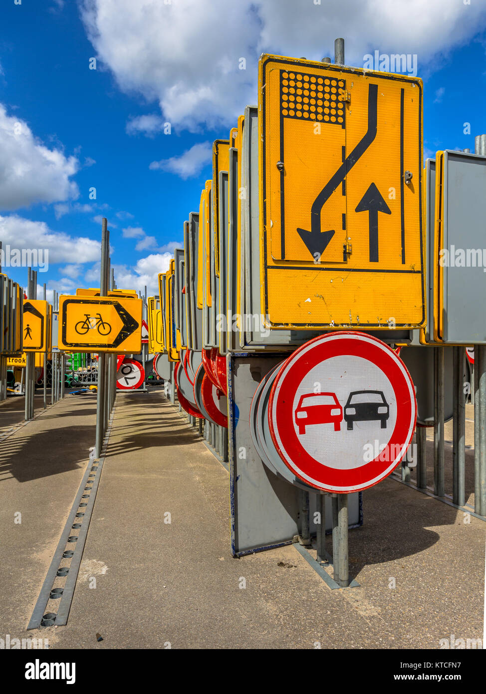 Gelbe Straße Verengung und überholverbot Zeichen unter anderen Zeilen von Verkehrszeichen warten in Straßenbauprojekte angestellt zu werden. Stockfoto