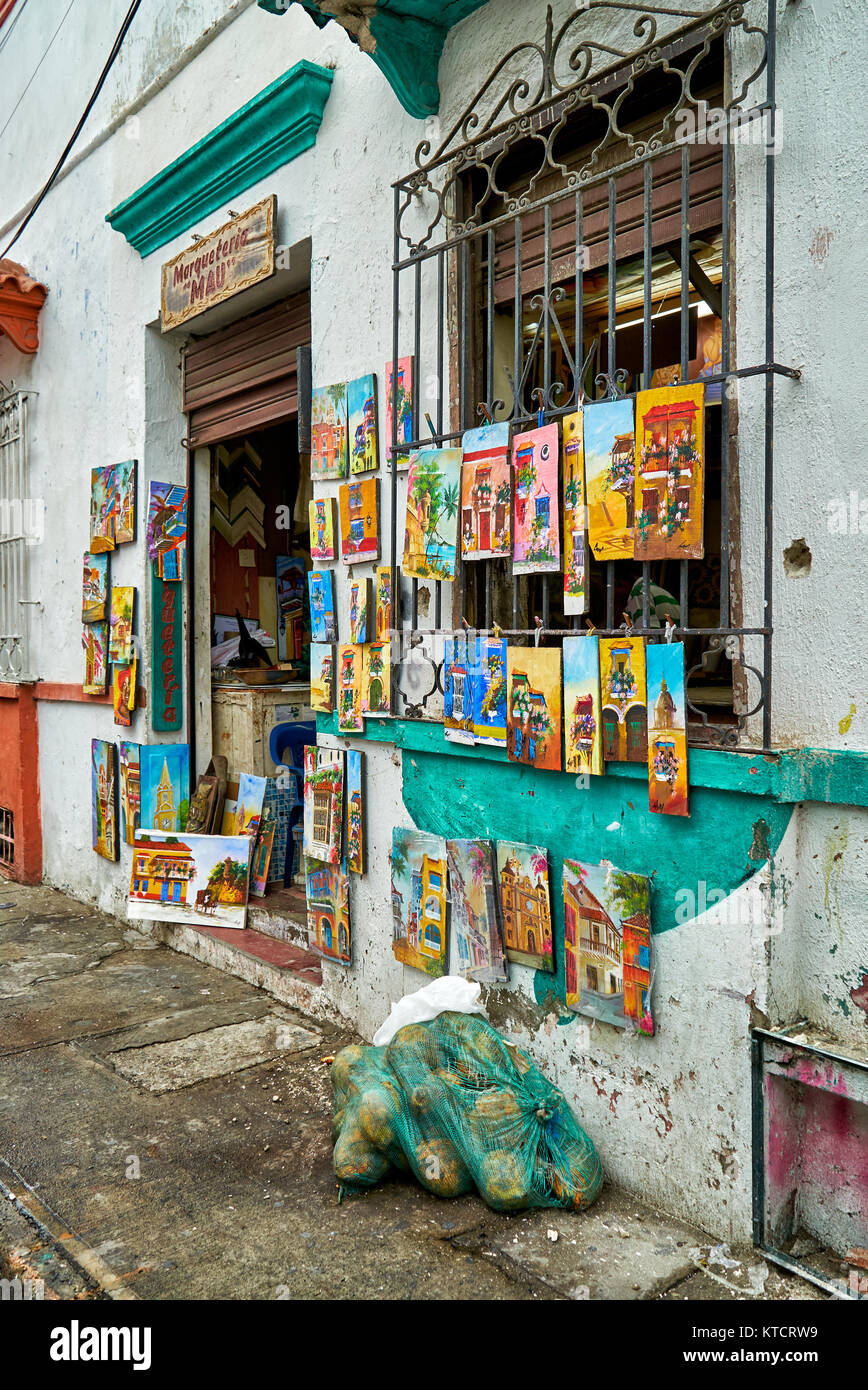 Kleiner Laden mit Gemälden von vergitterten Fenster bei typischen Fassaden von Cartagena de Indias, Kolumbien, Südamerika Stockfoto