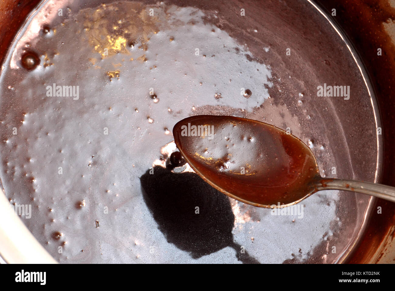 Lecker geschmolzene Schokolade in einem Löffel und einem weißen Topf. Stockfoto