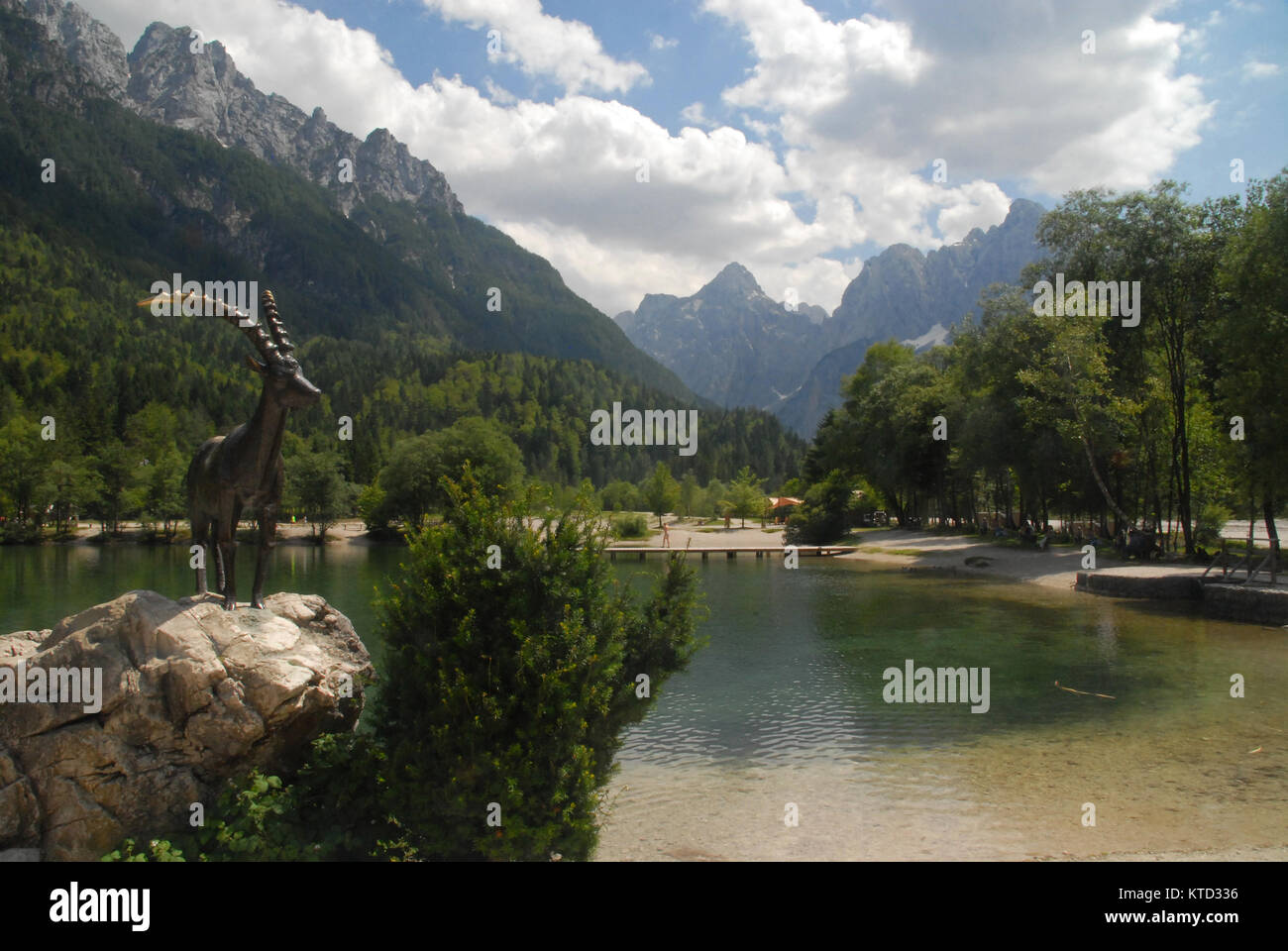 Statue des Goldhorn auf einem Felsblock am See Jasna in Kranjska Gora und Triglav Nationalpark Stockfoto