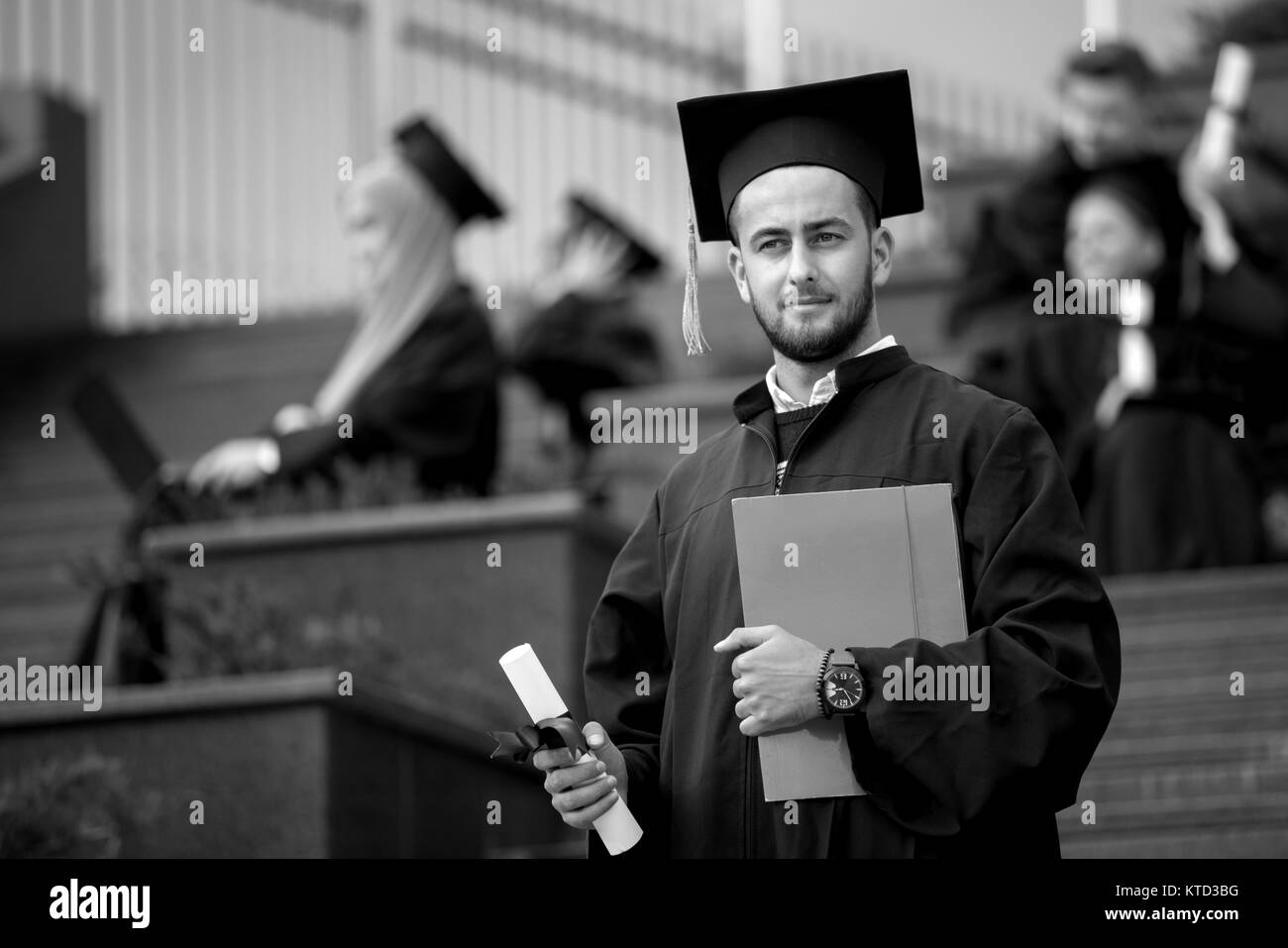 Junge stolz und zuversichtlich Absolvent für ein Foto posiert Stockfoto