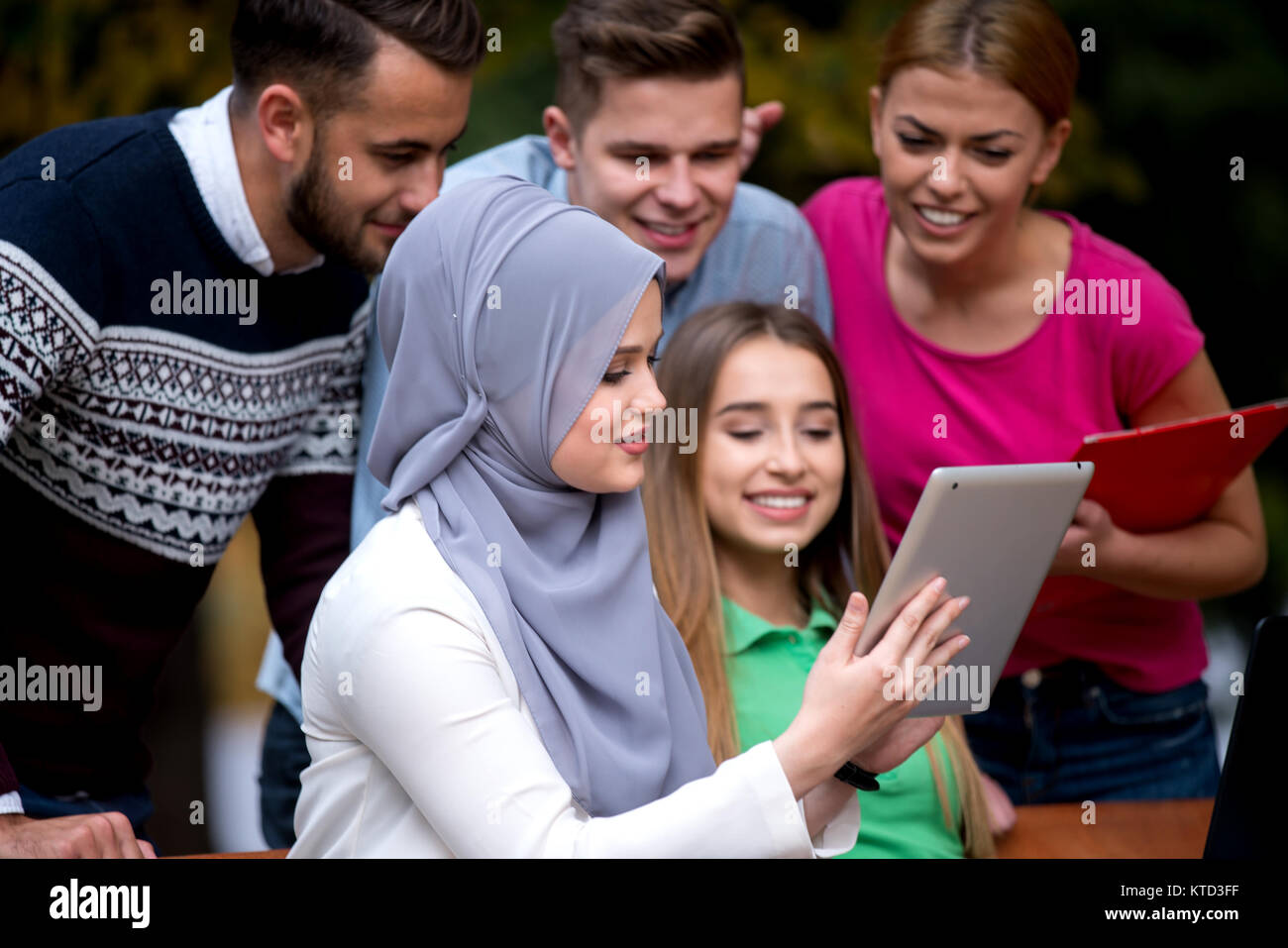 Gruppe von Jugendlichen mit Notebook und Tablet-PC auf einer Parkbank, Spass haben, Reden, heraus hängen Stockfoto
