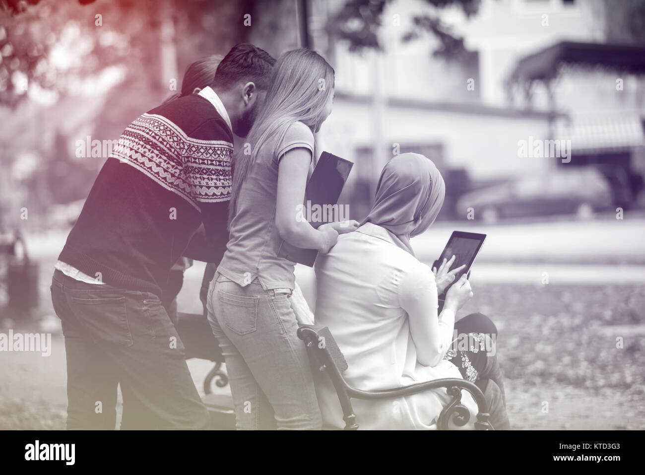 Gruppe von Jugendlichen mit Notebook und Tablet-PC auf einer Parkbank, Spass haben, Reden, heraus hängen Stockfoto