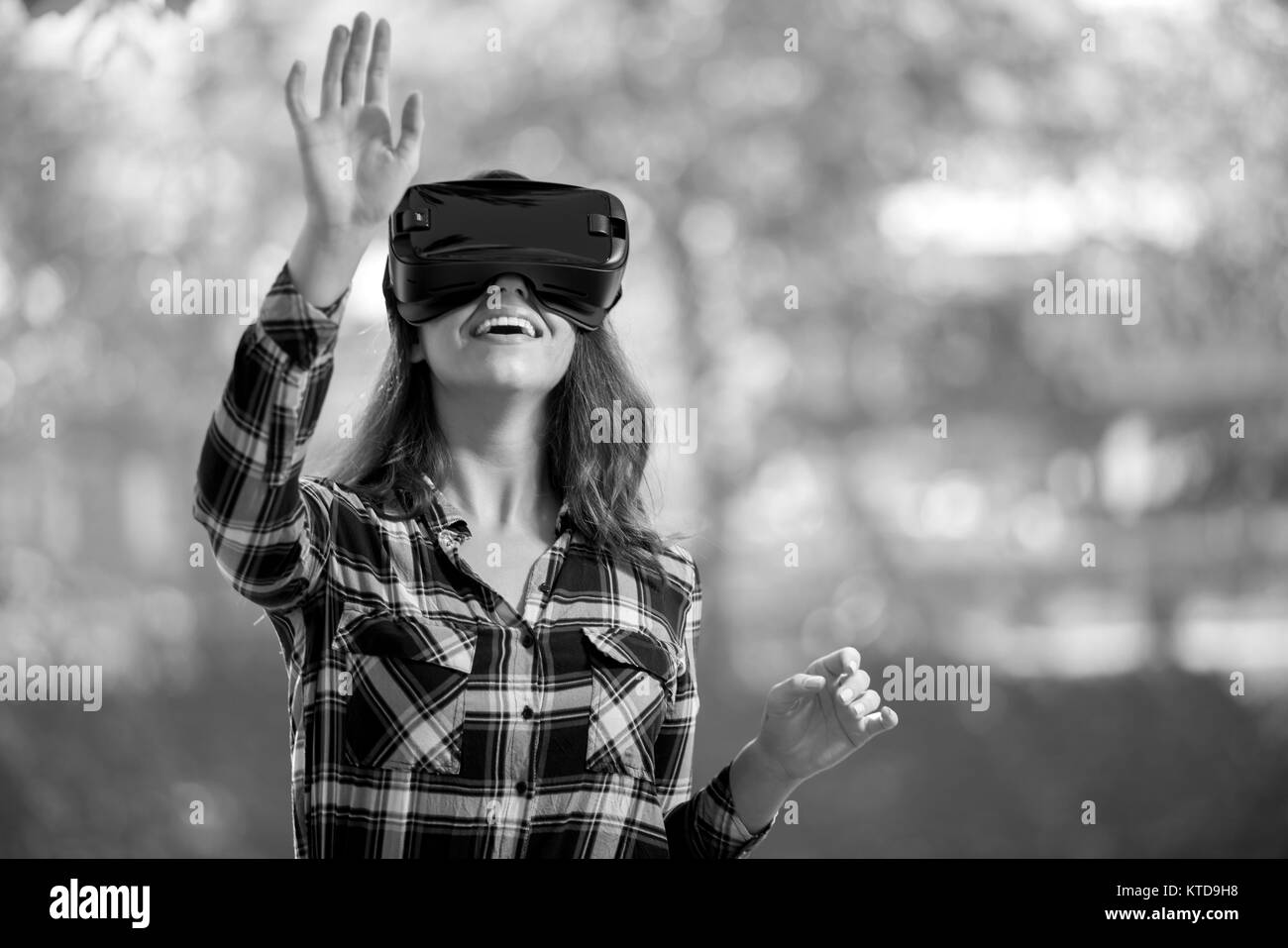 Hübsches Mädchen mit VR-Headset draußen im Park Spaß Stockfoto