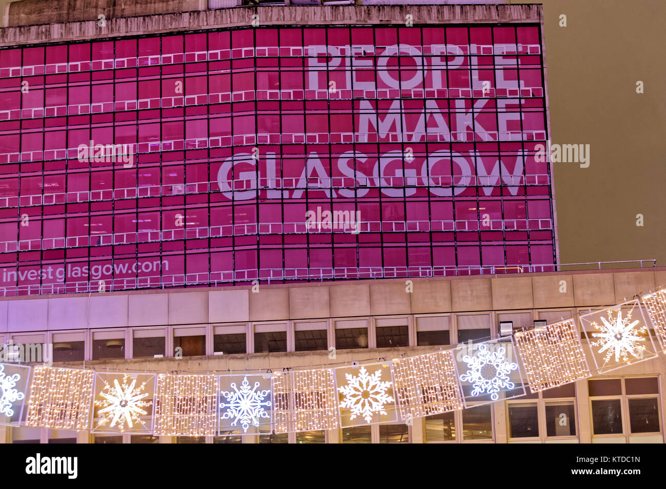 Brutalist konkrete Gebäude mit Menschen machen Glasgow Zeichen vom George Square bei Nacht gesehen Stockfoto