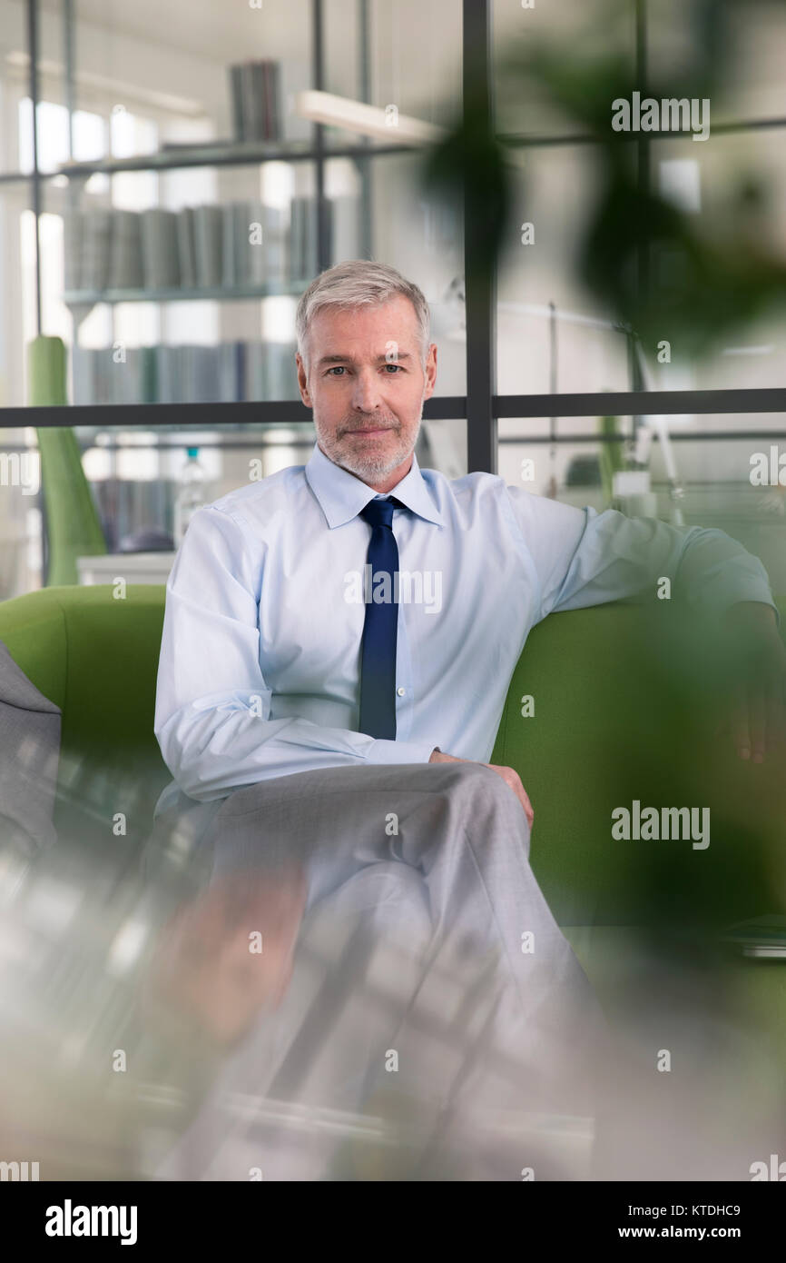 Reifen Geschäftsmann sitzen auf der Couch im Büro, usind Laptop Stockfoto