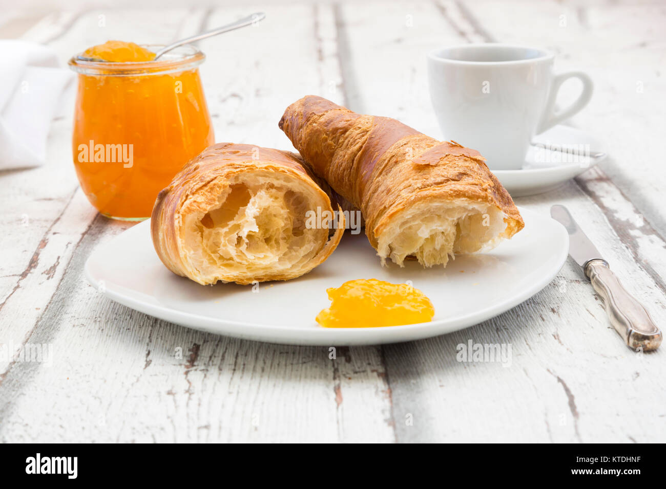 Croissant Frühstück, Aprikosenmarmelade und Tasse Kaffee Stockfoto