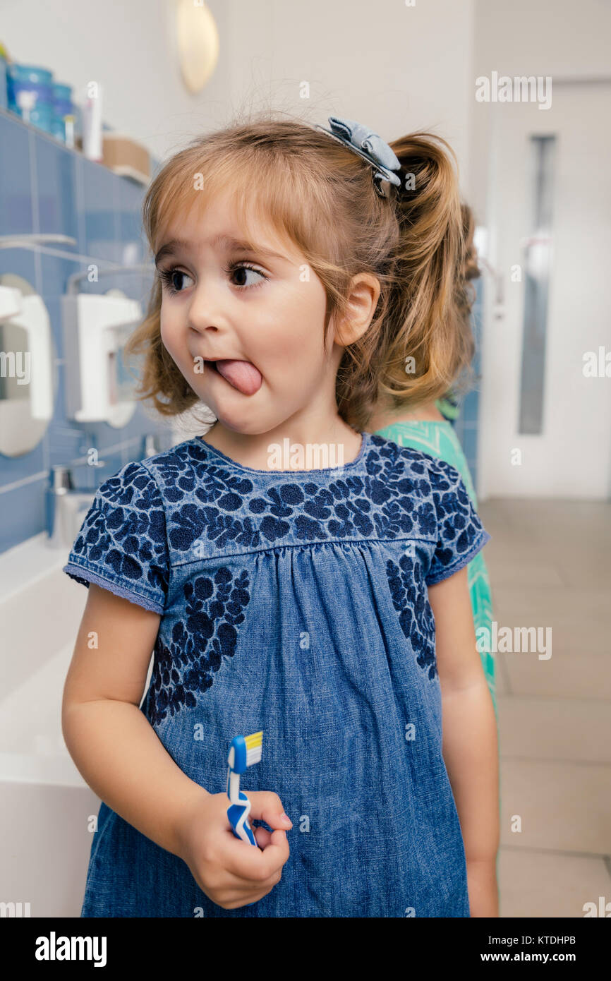 Portrait von Mädchen mit Zahnbürste im Badezimmer von einem Kindergarten Stockfoto