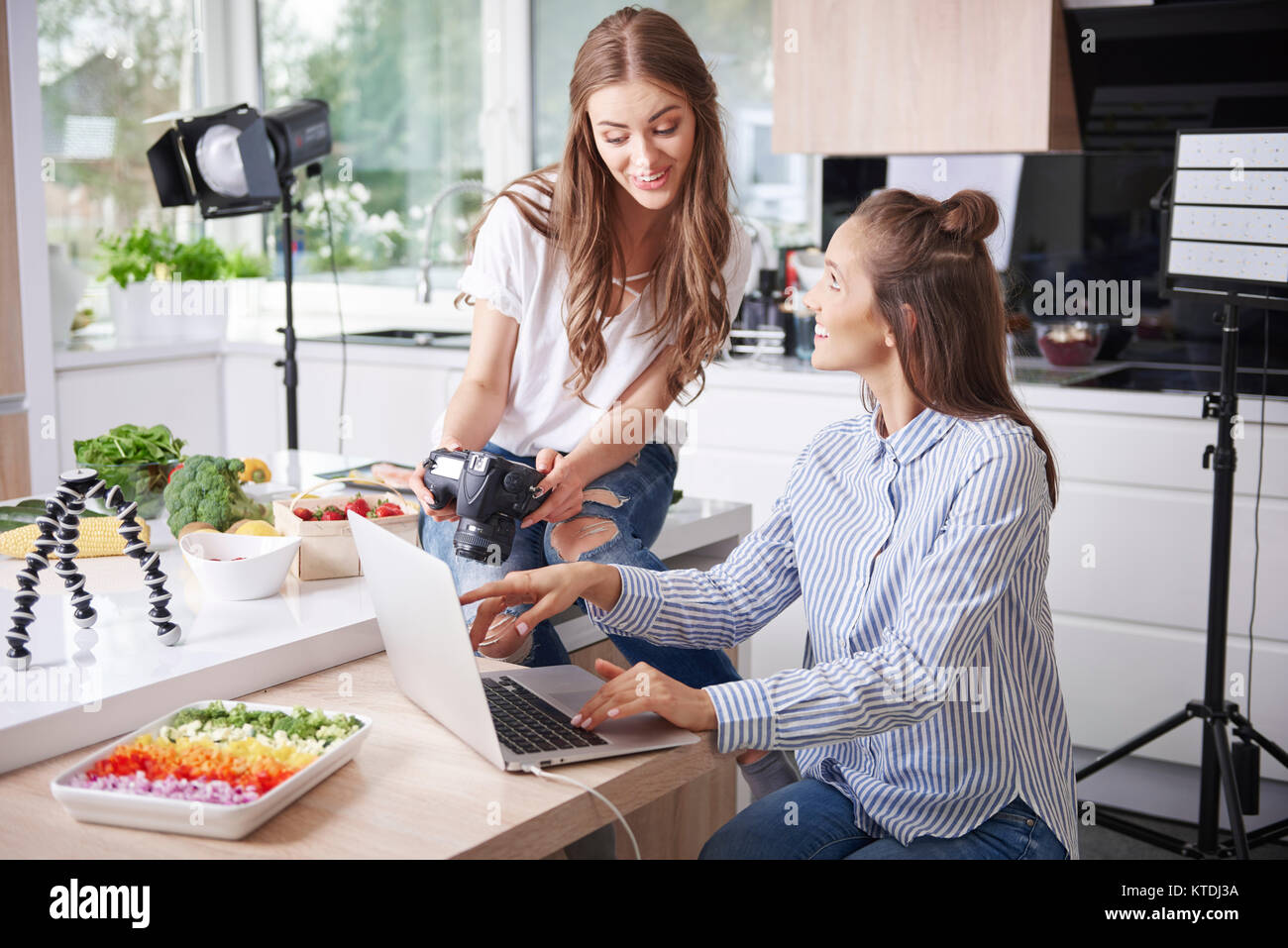 Zwei Blogger mit Laptop und Kamera in der Küche Stockfoto