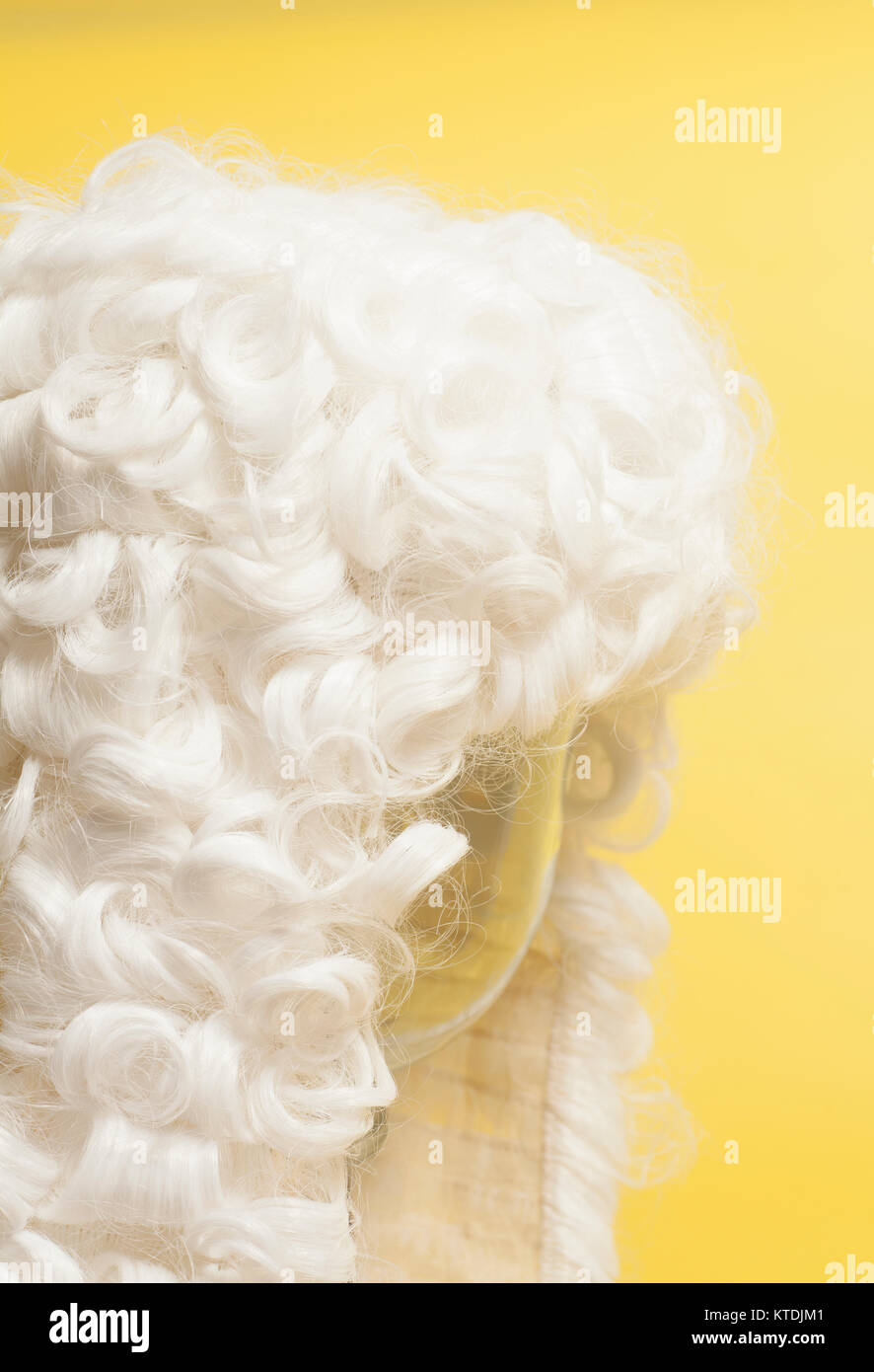 Perücke auf gelbem Hintergrund beurteilen. Stockfoto