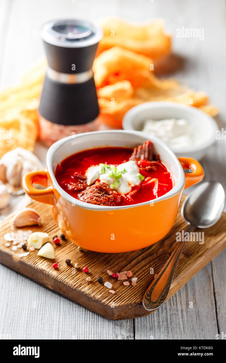 Traditionelle Suppe der Russischen und ukrainischen Küche borsch. Fleisch, Suppe mit Rüben im Orange Bowl auf einem hellen Hintergrund. Stockfoto