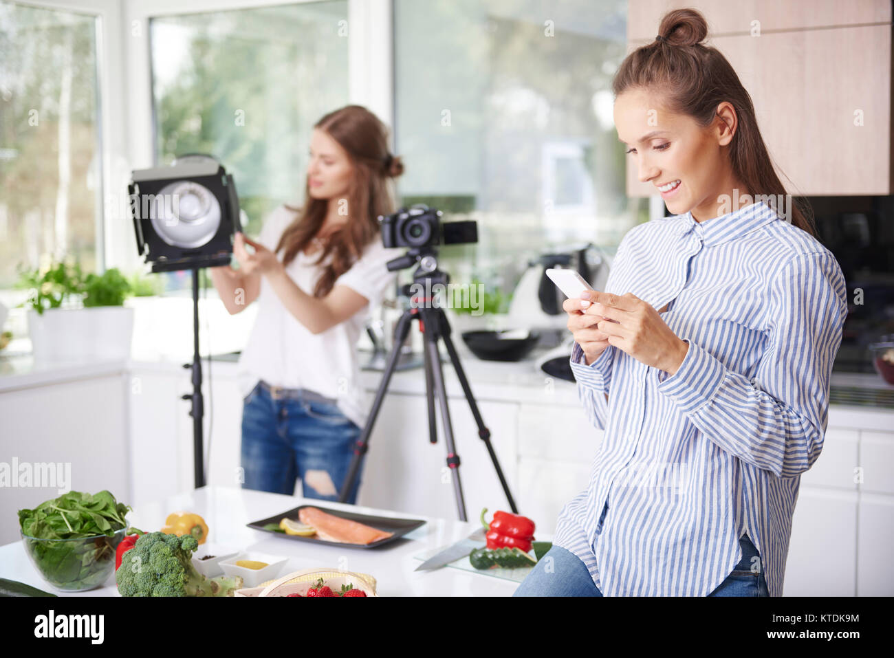 Frau mit Smartphone vor dem Kochen Stockfoto