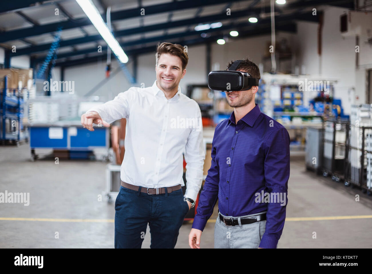 Zwei Mitarbeiter in einer Besprechung, einer VR-Brille tragen Stockfoto