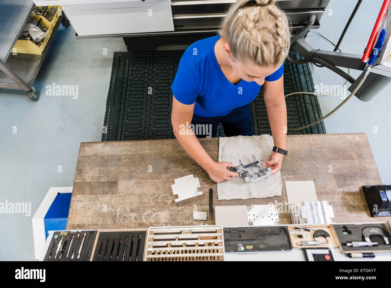 Frau Messung Werkstück aus Metall Stockfoto