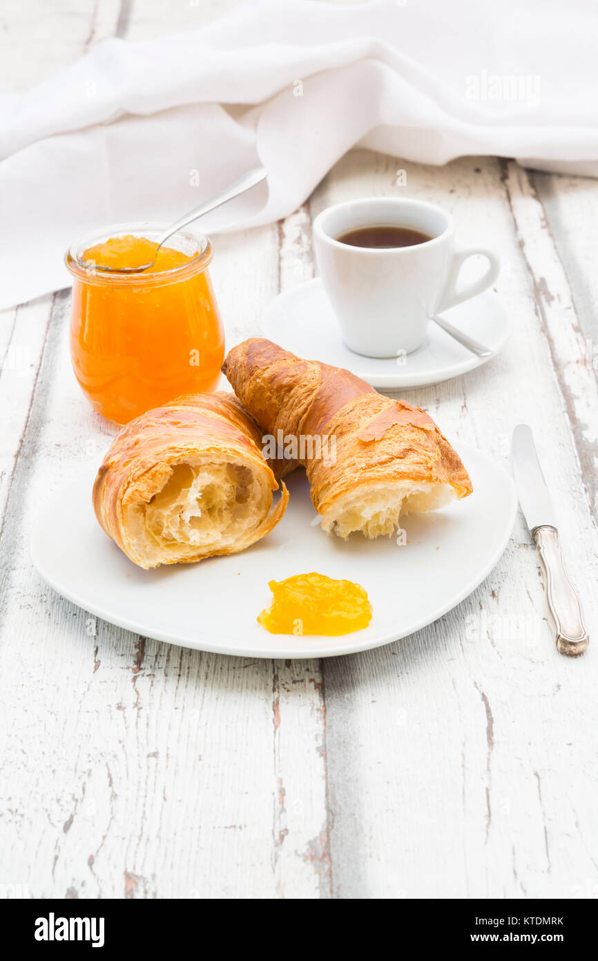 Croissant Frühstück, Aprikosenmarmelade und Tasse Kaffee Stockfoto