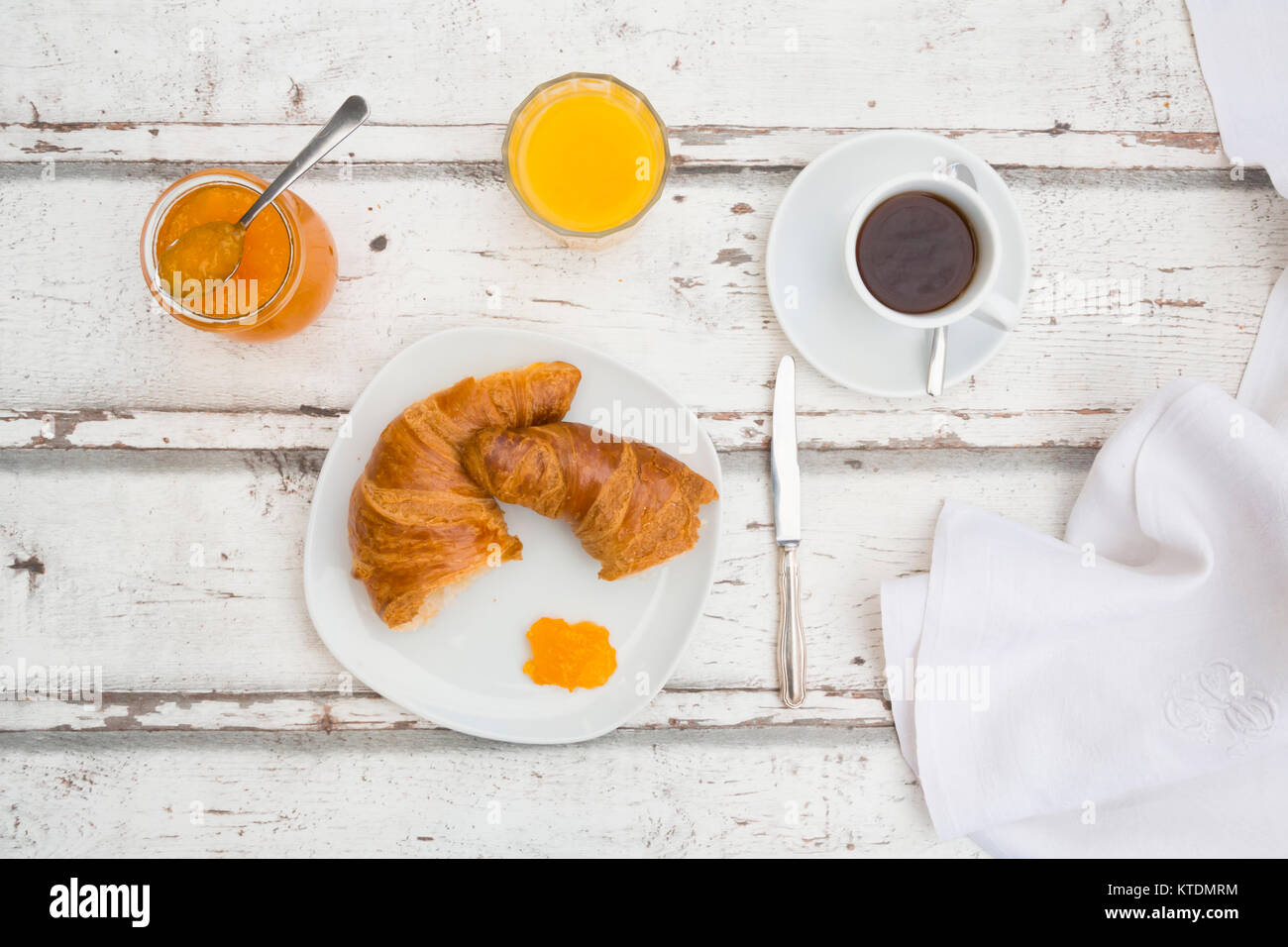 Croissant Frühstück, Aprikosenmarmelade, Tasse Kaffee und Orangensaft Stockfoto