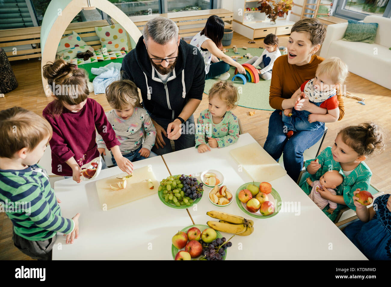 Gruppe von Kindern und Lehrern Vorbereitung Obst im Kindergarten Stockfoto