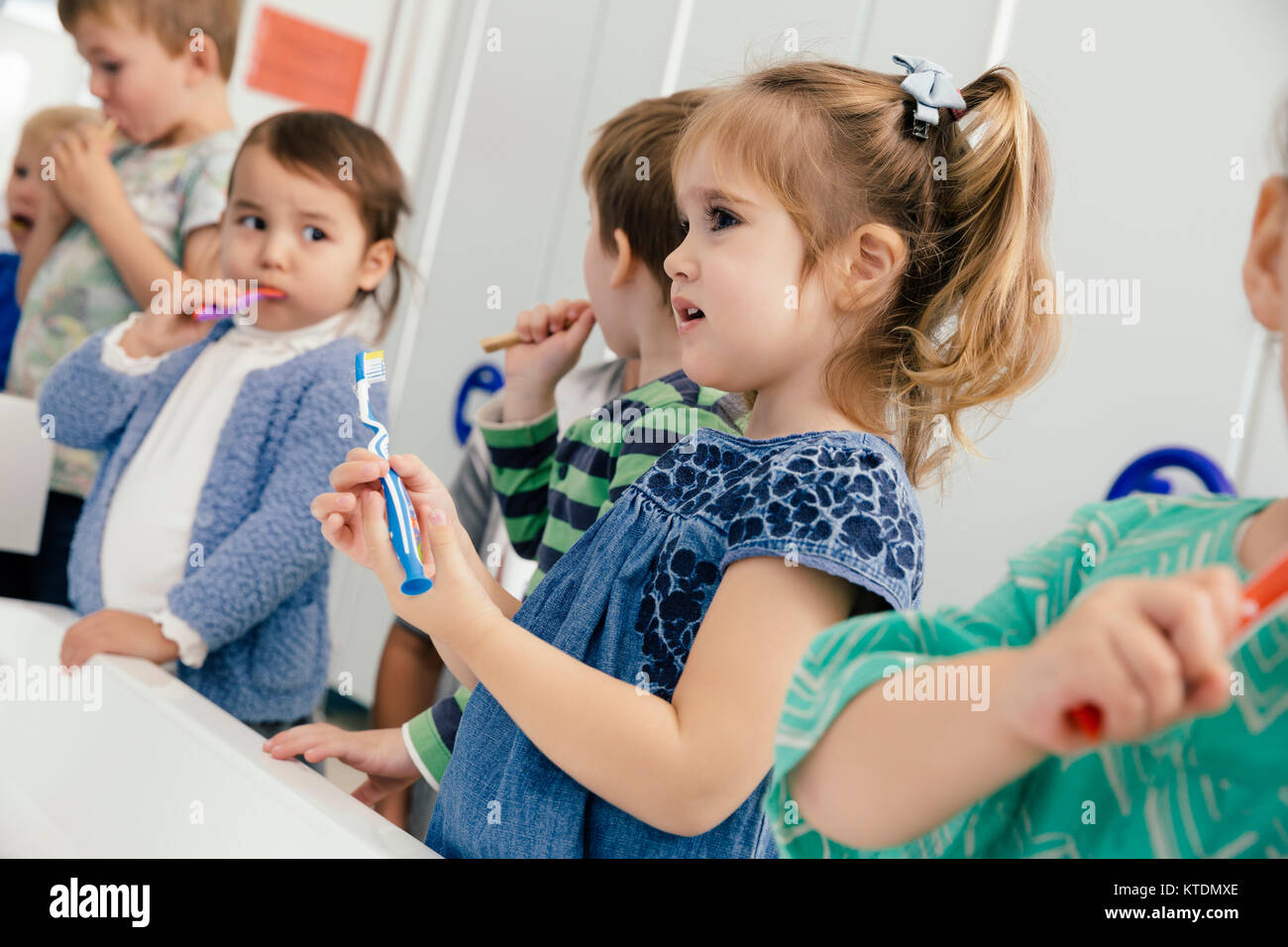 Kinder putzen ihre Zähne im Badezimmer von einem Kindergarten Stockfoto