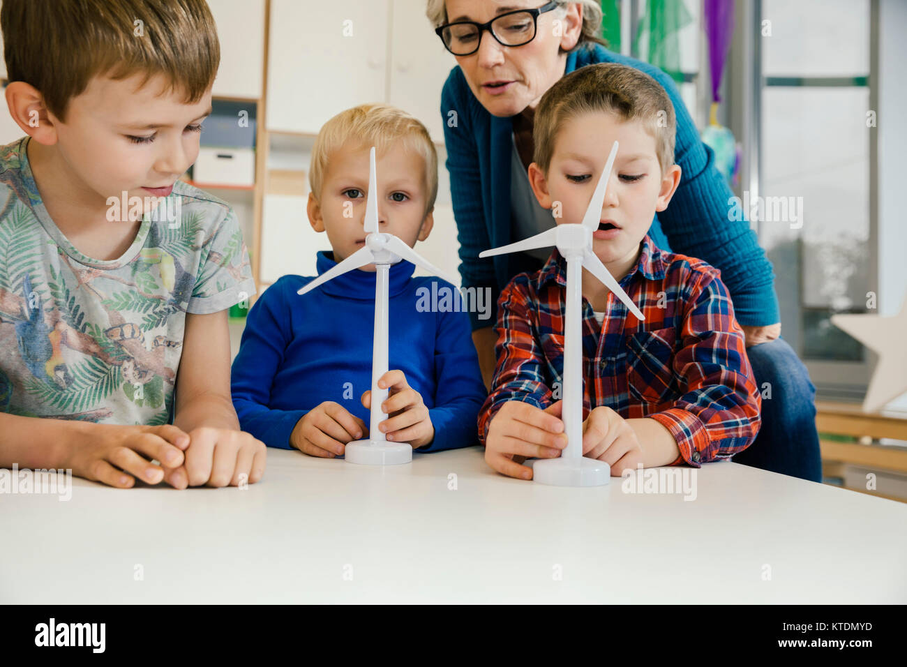 Jungen und pre-Schule Lehrer an der Windenergieanlage Modelle in Kindergarten suchen Stockfoto