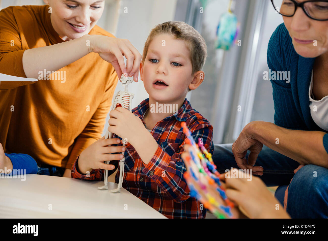 Junge und Erzieherinnen an anatomischen Modell im Kindergarten suchen Stockfoto