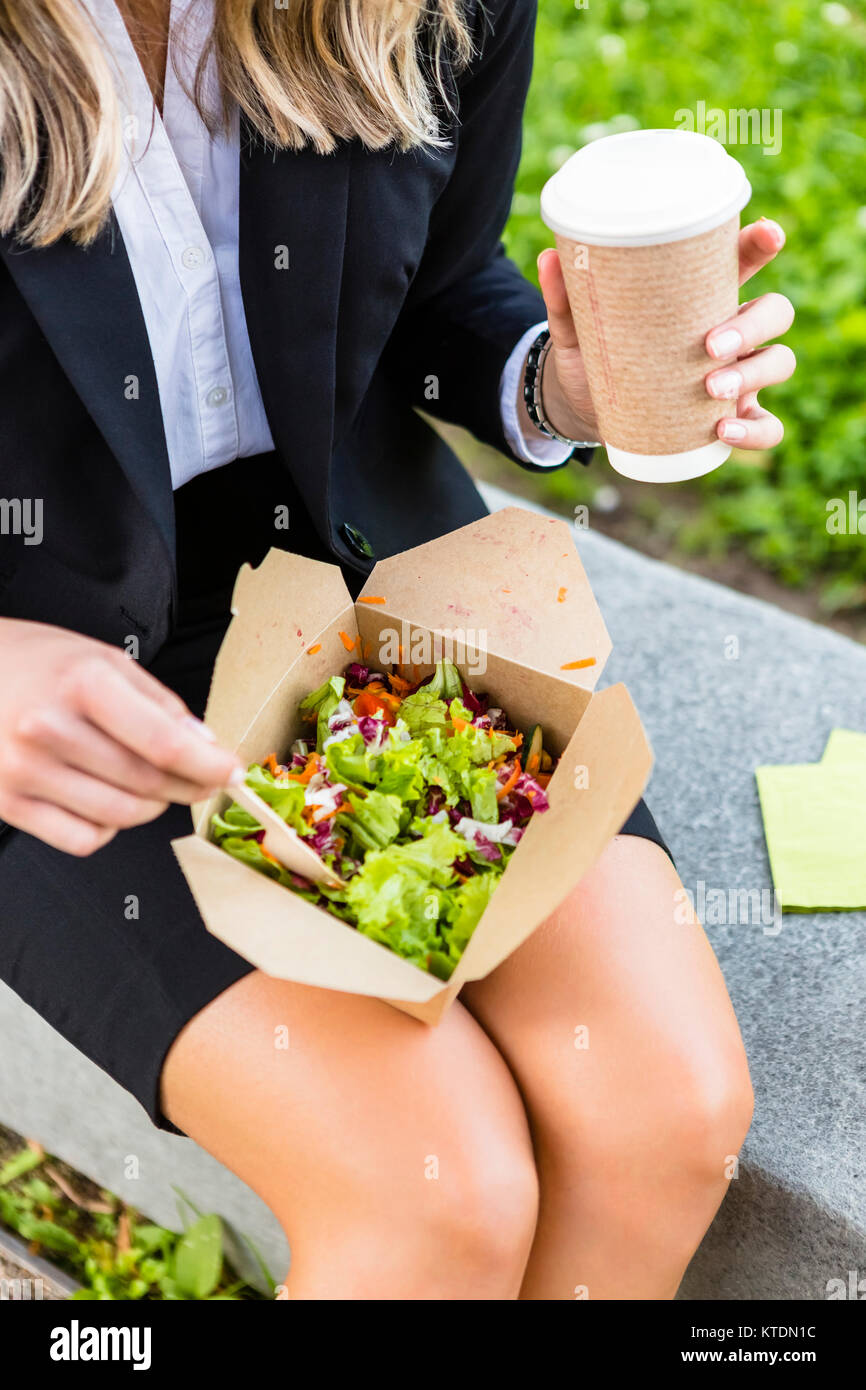Geschäftsfrau mit Mittagessen im Freien, Teilansicht Stockfoto