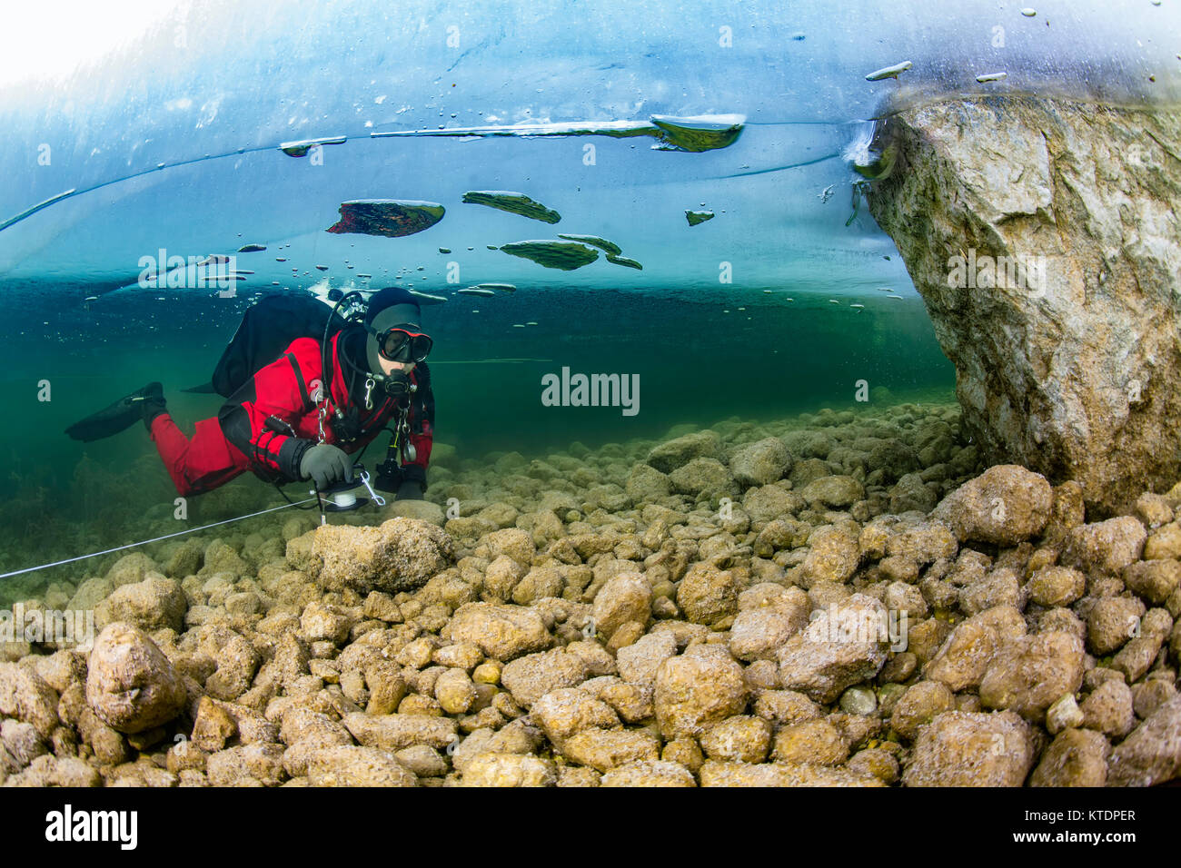 Österreich, Steiermark, Grundlsee, Scuba Diver unter Eisscholle Stockfoto