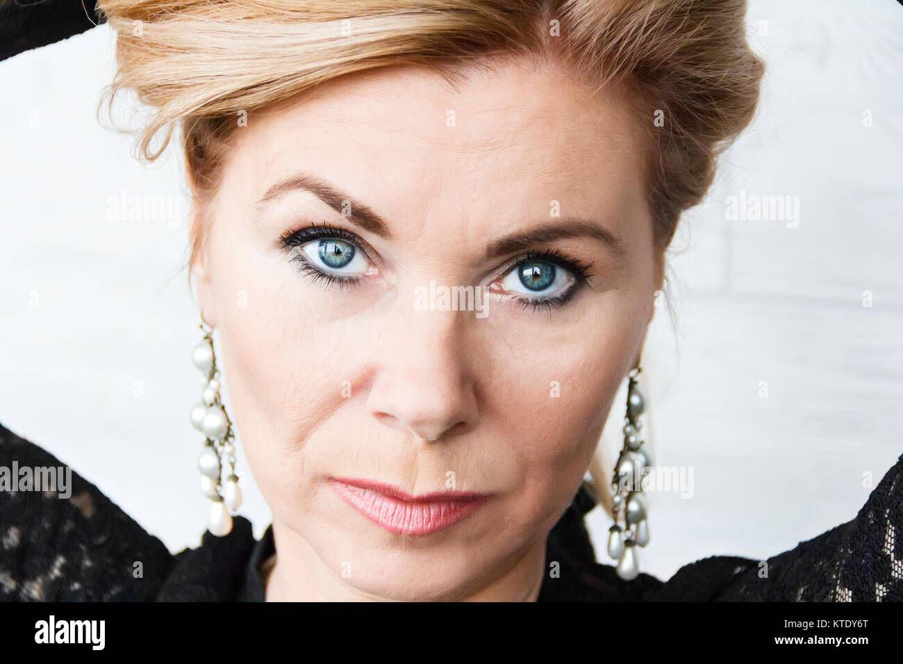 Horizontale Portrait von blonde Frau mit großen Ohrringe auf weißem Hintergrund Stockfoto